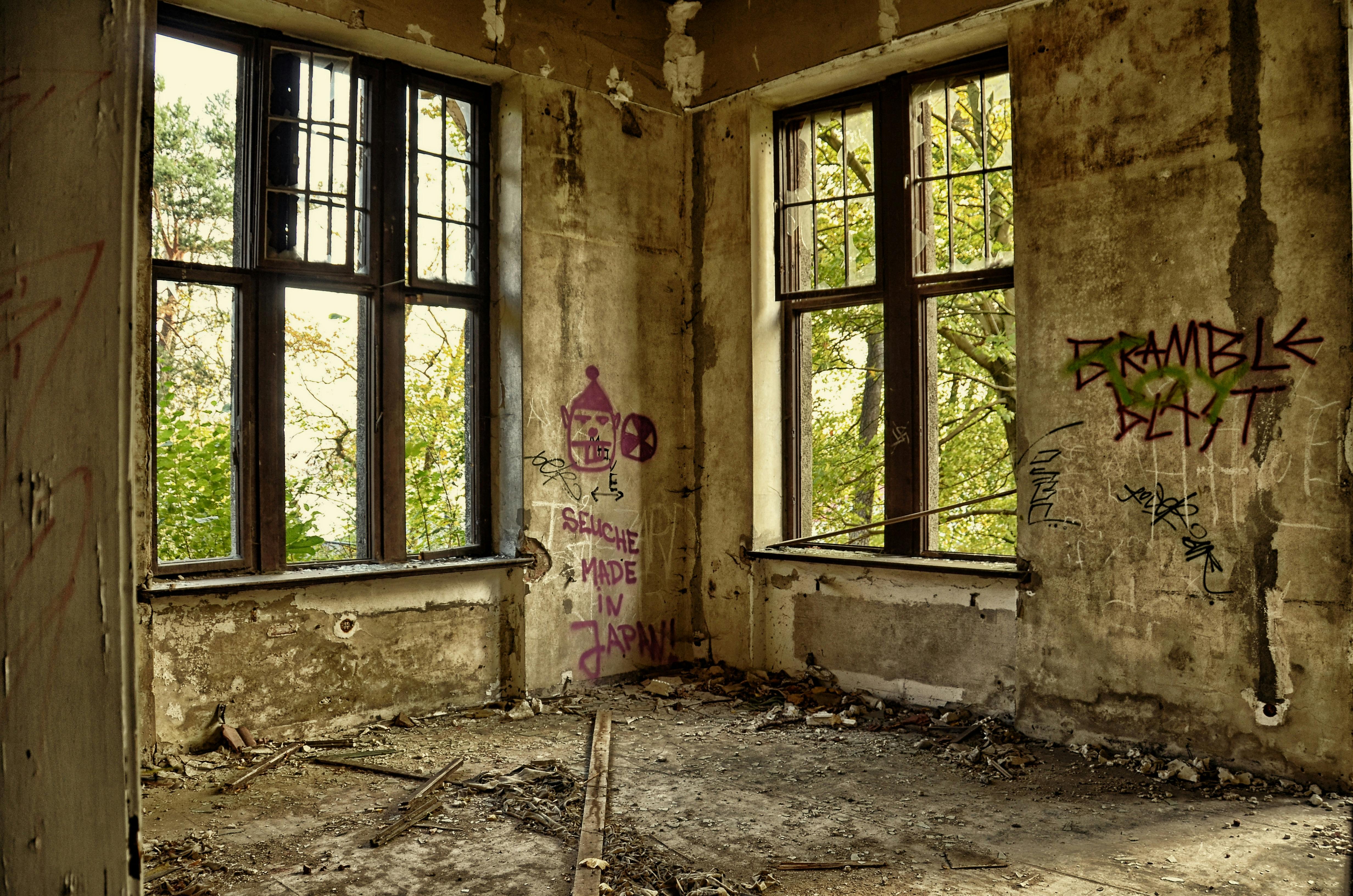 Image of abandoned room, with concrete walls that have graffiti